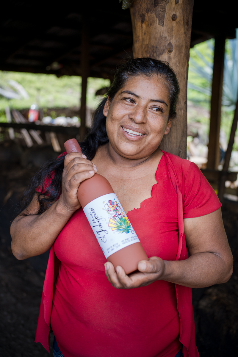 Justina Ruiz Perez proudly holding her mezcal in the village of Sola de Vega